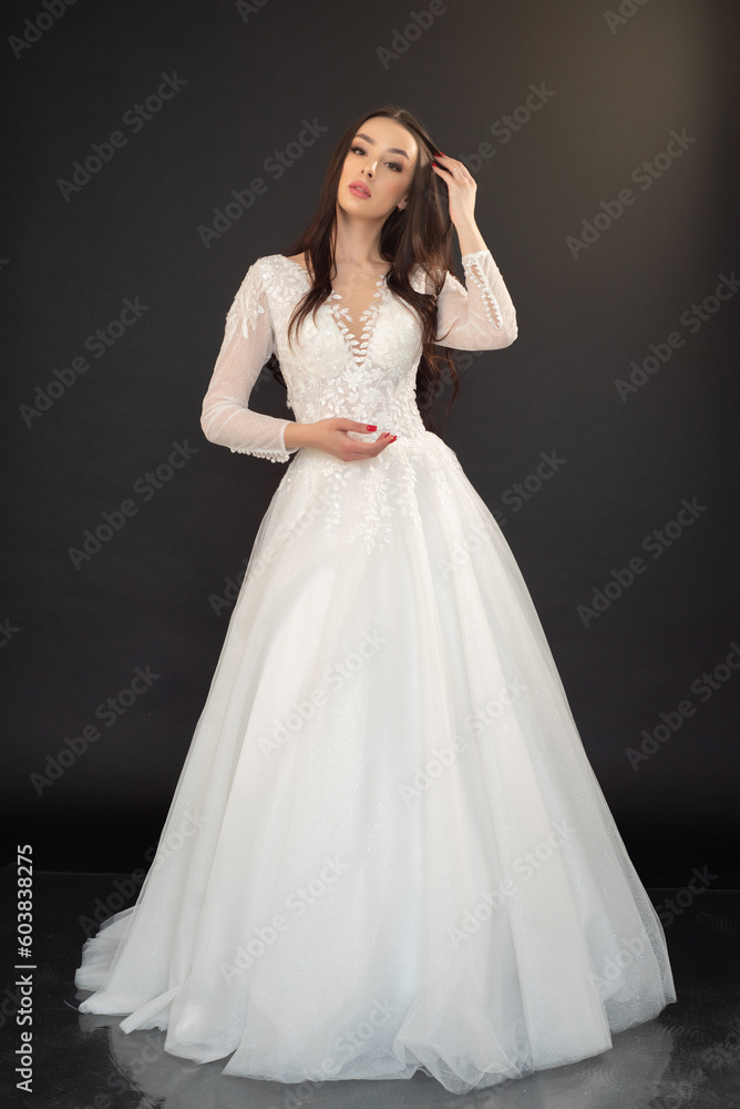 Stylish beautiful woman bride in wedding dress on black background