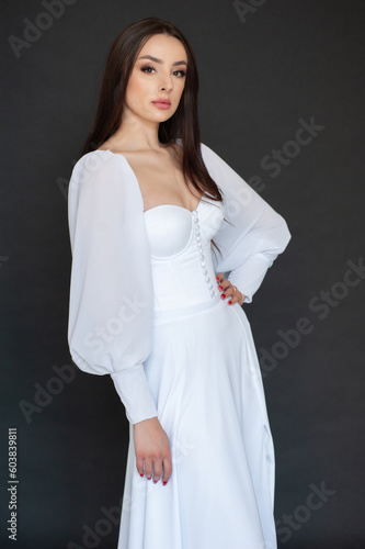 Stylish beautiful woman bride in wedding dress on black background