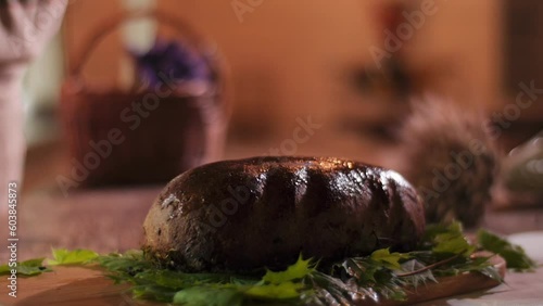 close up dolly shot of a woman moistening a loaf of freshly baked rye bread with water photo