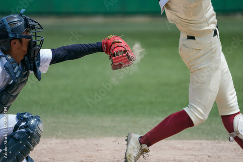 野球の試合中にピッチャーが投げてバッターが空振りしキャッチャーのミットにボールがズバッと収まり土煙が上がる瞬間