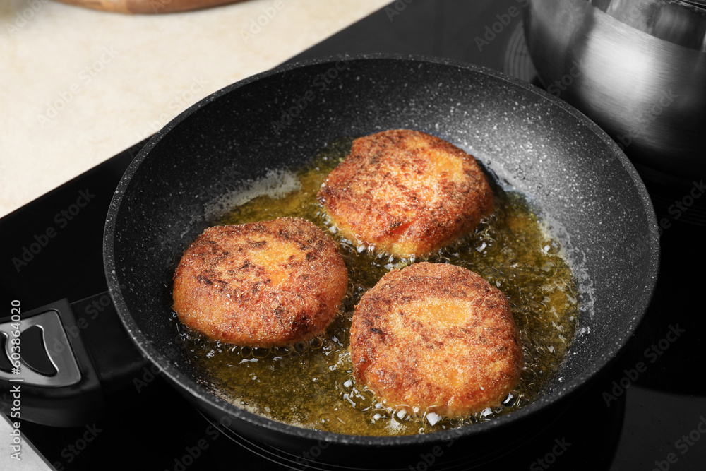 Cooking vegan cutlets in frying pan on stove, closeup Cooking vegan cutlets in frying pan on stove, closeup