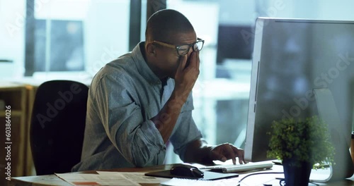 Young, man and business with computer is tired with glasses and is working hard at the office. Professional, fatigue and pc is on the internet with a headache at night is frustrated with stress.