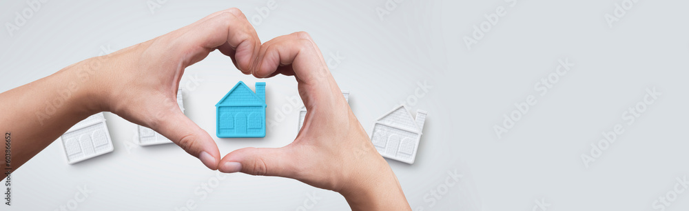 heart shaped hand focusing on a house - concept of real estate purchase and perfect place to live heart shaped hand focusing on a house - concept of real estate purchase and perfect place to live