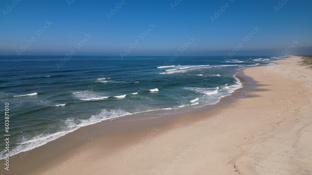 Side view of waves crashing on sandy beach
