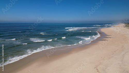 Side view of waves crashing on sandy beach