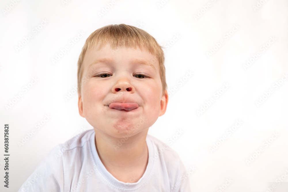 Portrait of a child boy showing his tongue on white background. grimace Portrait of a child boy showing his tongue on white background. grimace