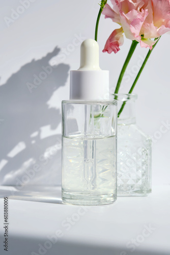 Serum with a dropper with spring flowers.
