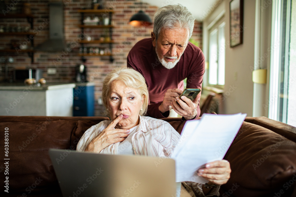Senior couple going over their bills in a living room