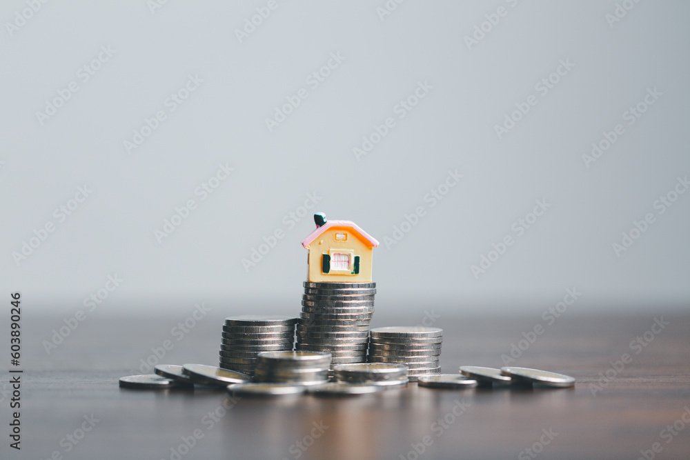 Coins stack with mini house on wooden table, home loan, Save money concept, Property investment, house loan, reverse mortgage, gold coins money stack growth, saving money coins stack future for home. Coins stack with mini house on wooden table, home loan, Save money concept, Property investment, house loan, reverse mortgage, gold coins money stack growth, saving money coins stack future for home.