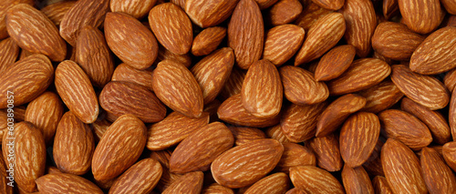 Background of big raw peeled almonds situated arbitrarily