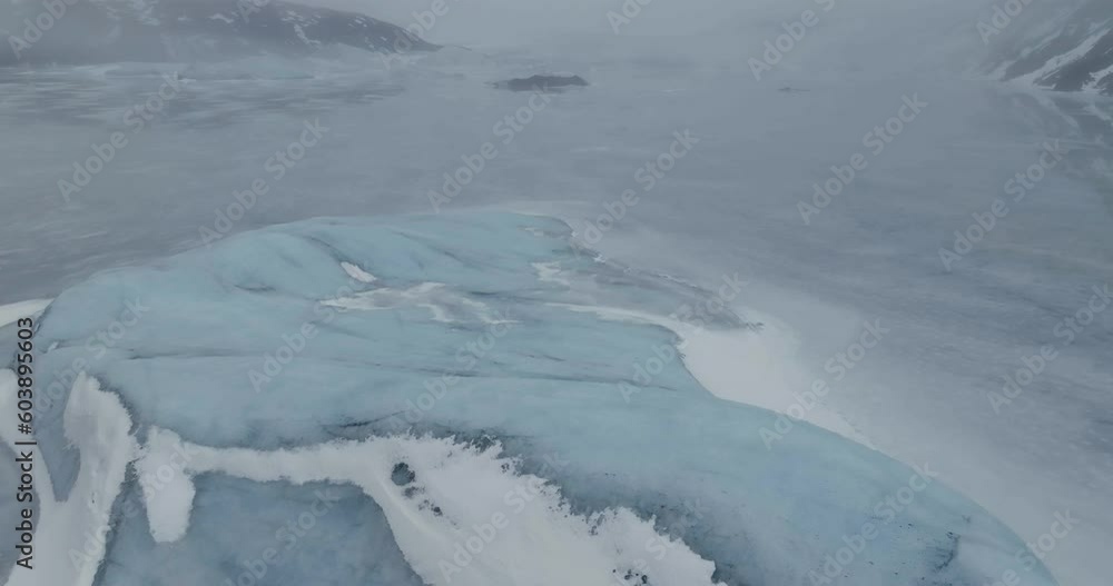 Aerial View of Iceberg in Glacial Lake Under Glacier Covered With Snow and Fog, Drone Shot Aerial View of Iceberg in Glacial Lake Under Glacier Covered With Snow and Fog, Drone Shot