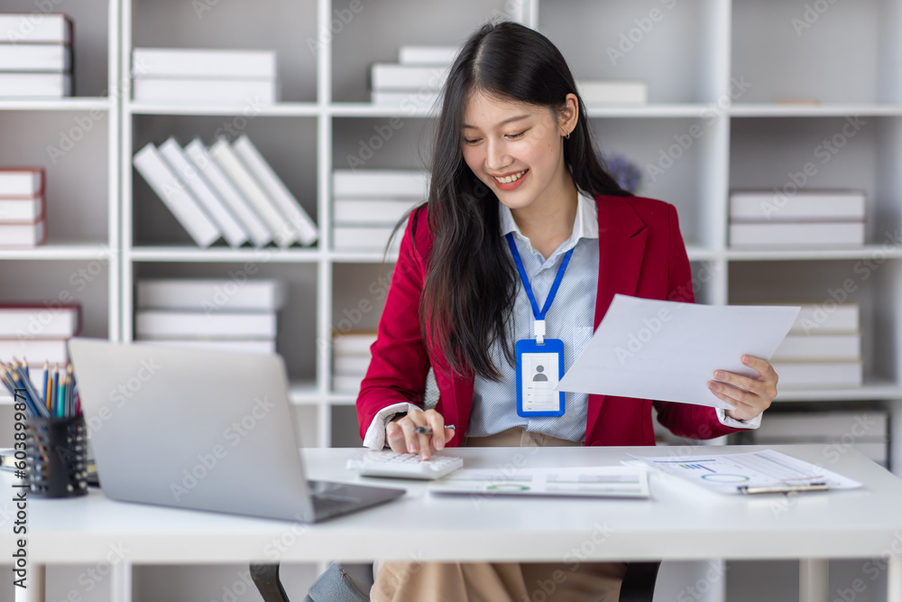 Asian Businesswoman Using laptop computer and working at office with calculator document on desk, doing planning analyzing the financial report, business plan investment, finance analysis concept. Asian Businesswoman Using laptop computer and working at office with calculator document on desk, doing planning analyzing the financial report, business plan investment, finance analysis concept.