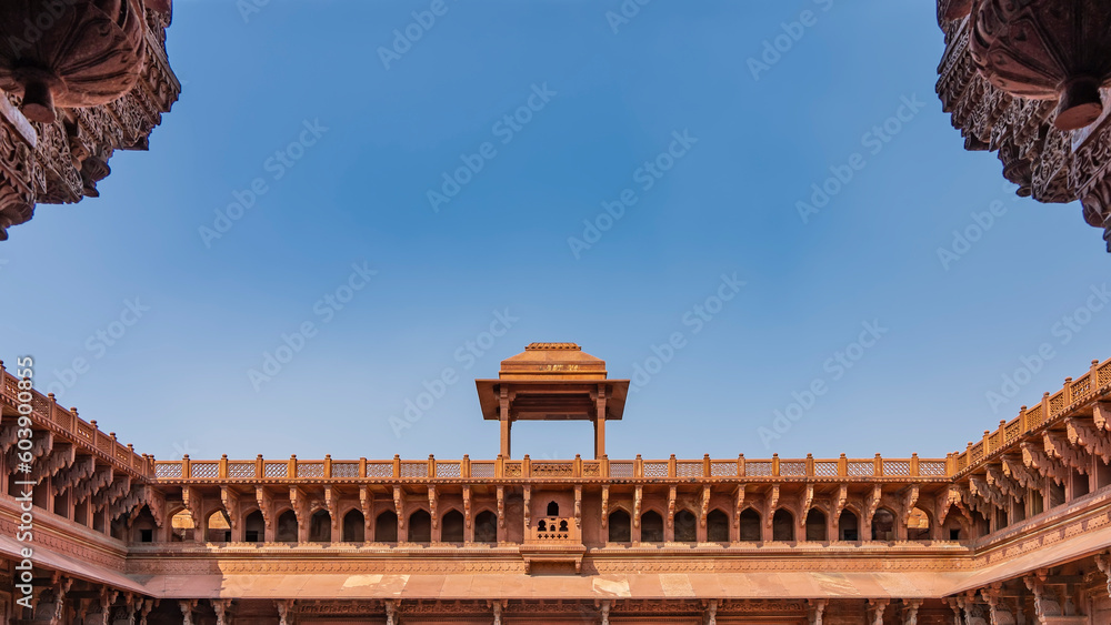 Obraz premium Details of the architecture of the Jahangir Mahal Palace. The upper part of the building with galleries, arches. There is a pavilion with a dome on the roof. Lattice fence around the perimeter. Agra