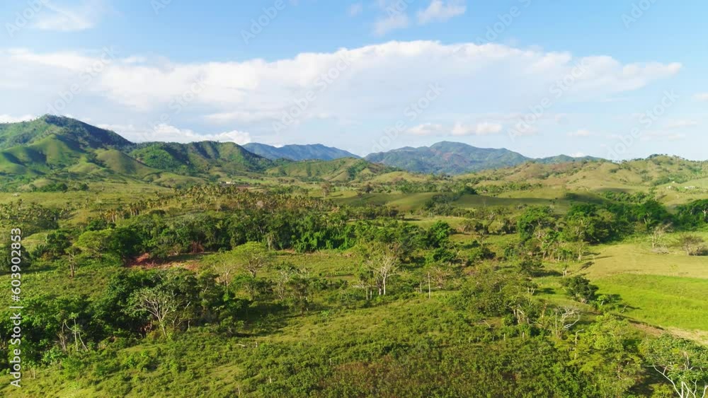 Aerial view of the endless lush pastures of the Dominican mountains and farmland. American Wildlife Landscape. Green grass and summer blue sky landscape. Rural mountain landscape. Aerial view of the endless lush pastures of the Dominican mountains and farmland. American Wildlife Landscape. Green grass and summer blue sky landscape. Rural mountain landscape.