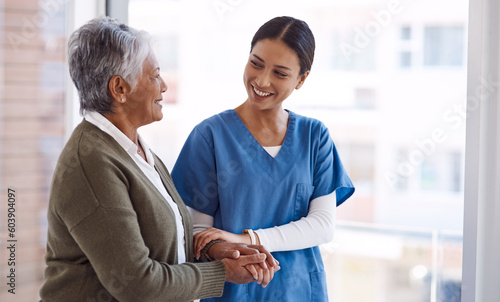 Support, caregiver with senior woman and holding hands for care indoors. Retirement, consulting and professional female nurse with elderly person smiling together for healthcare at nursing home photo