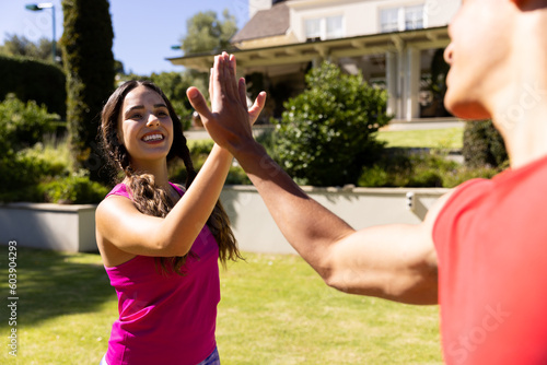 Happy diverse fit couple practicing yoga high fiving and smiling in sunny garden © WavebreakMediaMicro