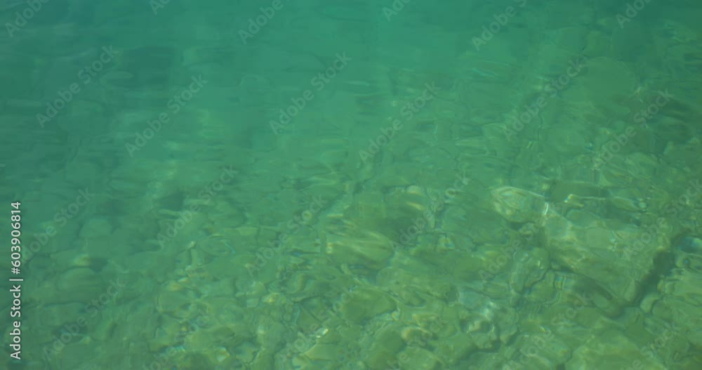 Quiet waters of the Adriatic Sea with clear water and rocky bottom. In the distance you can see the coast of Croatia and white sailboats Quiet waters of the Adriatic Sea with clear water and rocky bottom. In the distance you can see the coast of Croatia and white sailboats
