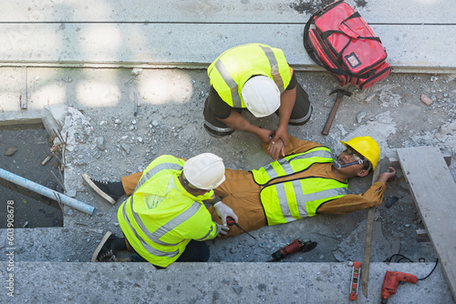 A construction worker had an accident at work, fell from a height, seriously injured. First aid to save the lives of construction site workers in an accident.