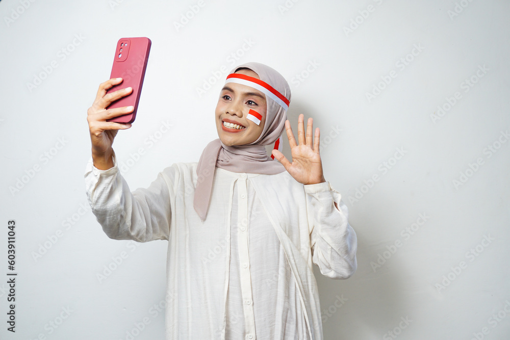Portrait of Young Asian Muslim Women celebrate Indonesian independence day using smartphones Portrait of Young Asian Muslim Women celebrate Indonesian independence day using smartphones