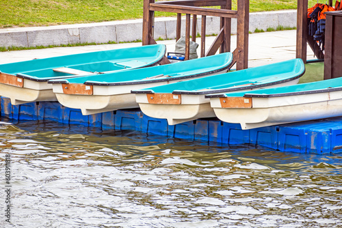 Pleasure rowing boats lie on the pier on a spring day