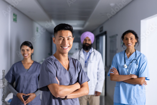 Group portrait of happy diverse male and female doctors standing in corridor at hospital photo