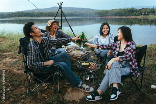 Asian LGBTQ+ couple drinking and barbecue in a romantic camping setting. Groups of friends and couples having a drink party in a camping atmosphere amidst forests and rivers. © VR Studio