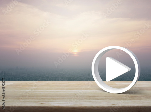 Play button 3d icon on wooden table over modern city tower and skyscraper at sunset sky, vintage style, Business music online concept