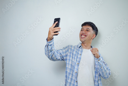 facial expression of happy asian man doing video call isolated on white background photo