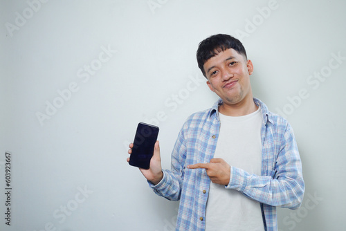 Asian man facial expression looking at the mobile phone isolated on white background photo