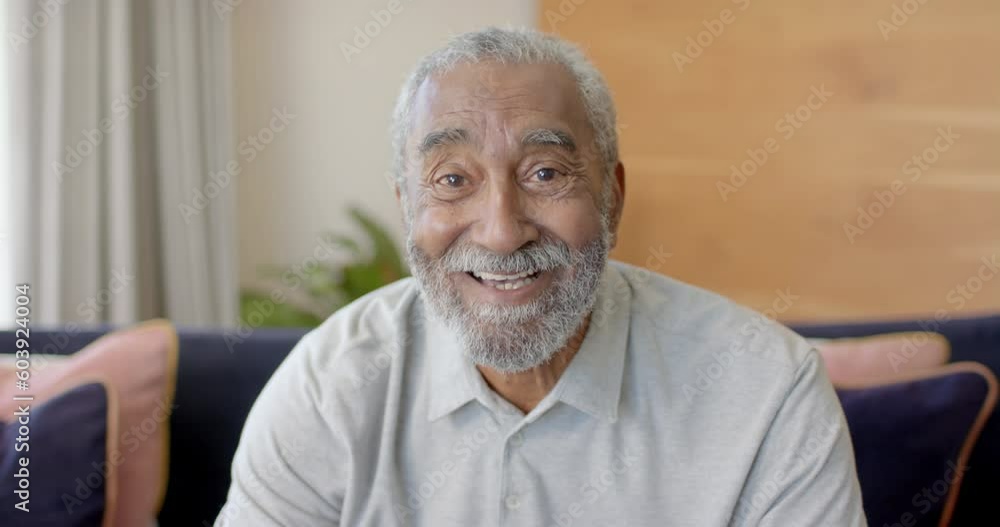 Portrait of happy senior biracial man making video call at home, unaltered, in slow motion Portrait of happy senior biracial man making video call at home, unaltered, in slow motion