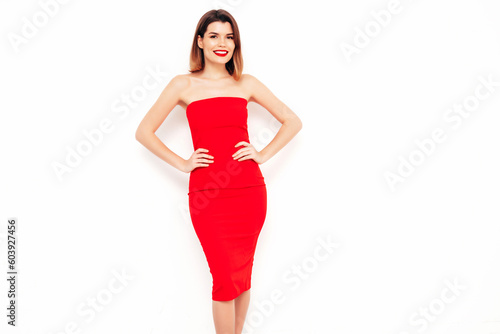 Young beautiful smiling female in trendy summer red evening dress. Sexy carefree brunette woman posing in studio, isolated on white. Positive model with evening makeup. Cheerful and happy