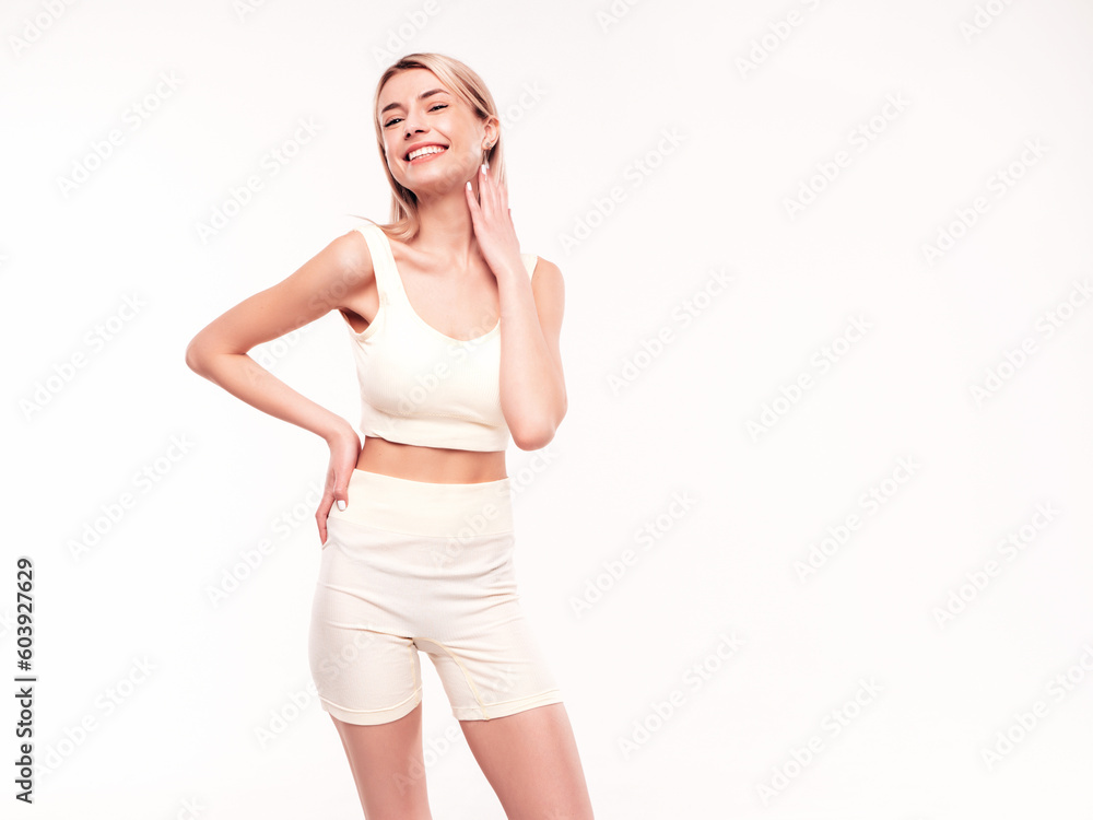 Young beautiful smiling blond female in summer cycling shorts clothes. Sexy carefree woman posing on white background in studio. Positive model having fun indoors. Cheerful and happy Young beautiful smiling blond female in summer cycling shorts clothes. Sexy carefree woman posing on white background in studio. Positive model having fun indoors. Cheerful and happy