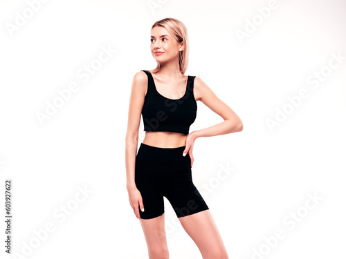 Young beautiful smiling blond female in summer black cycling shorts costume clothes. Sexy carefree woman posing on white in studio. Positive model having fun. Cheerful and happy