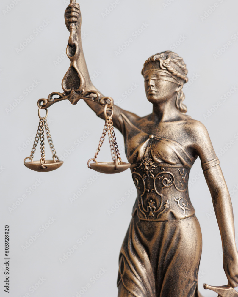 close-up themis goddess of justice statuette on light gray background. symbol of law with scales sword in hands. legal company or university of law and judicial structure. court acquittal of the - obrazy, fototapety, plakaty 