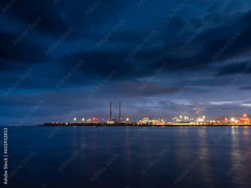 Illuminated dock area of Dublin port at night, Dark dramatic sky. Night shot. Transportation industry, Import and export gate of the country.