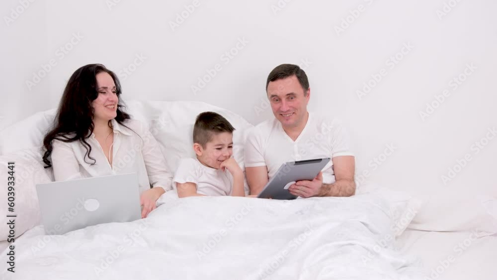man woman boy spend time together in bed holiday vacation chat have fun relax look at tablet real people live conversation love at home happiness joy success in gadgets place for ad text happy family man woman boy spend time together in bed holiday vacation chat have fun relax look at tablet real people live conversation love at home happiness joy success in gadgets place for ad text happy family
