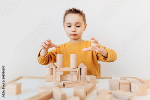 Kids Play Room, Smart pretty child building wooden blocks. Development and Construction Concept