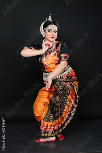 Woman performing Odissi dance in colorful costume. Indian classical dance forms.