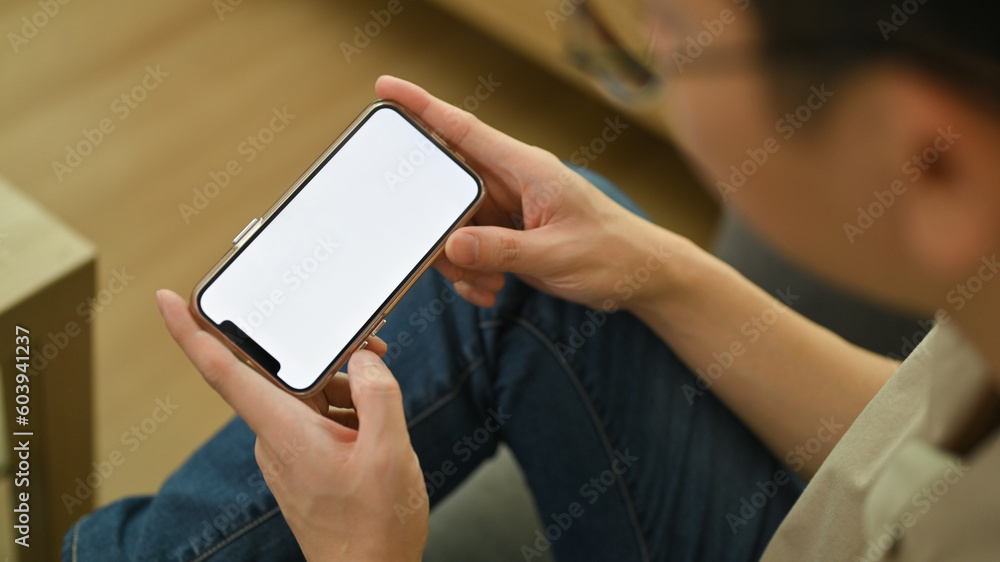 Closeup view of horizontal smartphone with blank screen in man hands. Empty space for your advertising text message