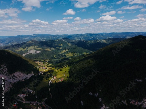 Landscape with forest, blue sky with clouds and mountain in front. Beautiful nature scenery with perfect cloudy sky in sunny day. Drone photo