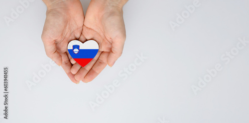 Tablou pe pânză The national flag of Slovenia in the shape of a heart in the hands