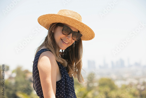 Smiling young woman with straw hat and sunglasses photo