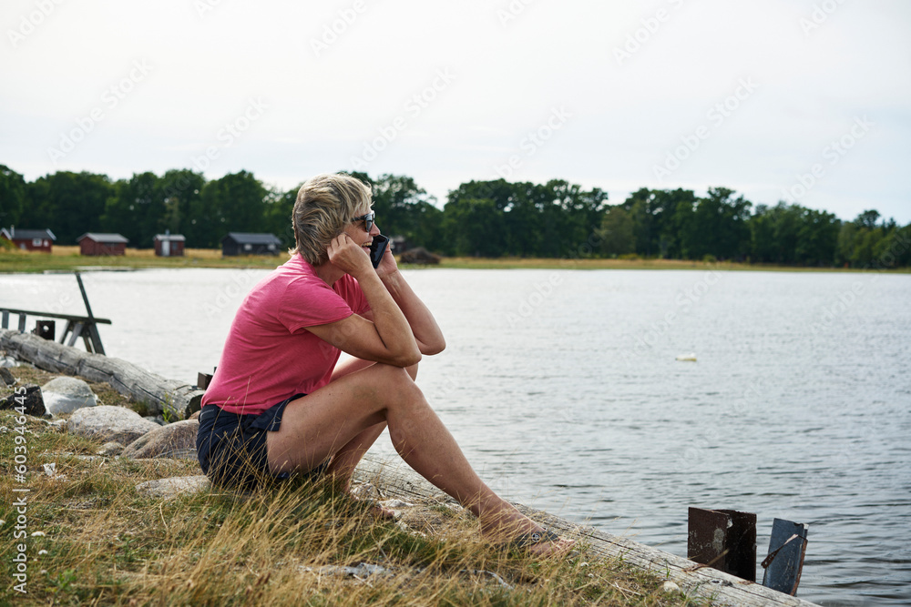 Woman talking on smartphone by sea Woman talking on smartphone by sea