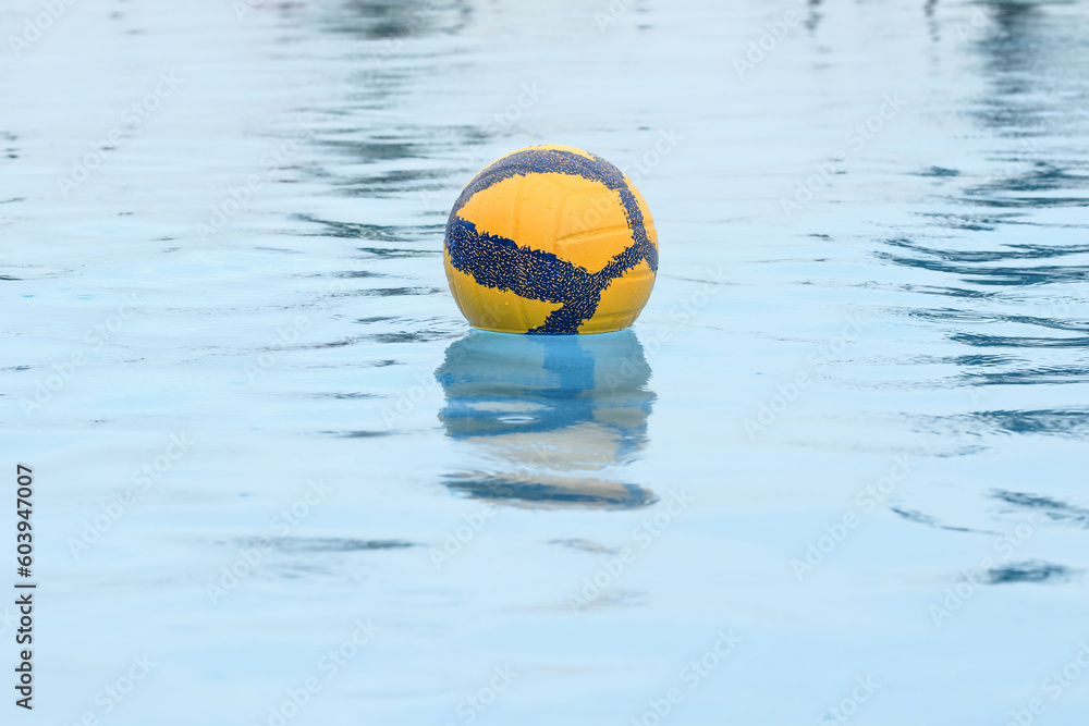 Voleyball lost in water pool, ball swimming in the pool by the sun.