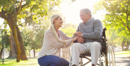 Happy, talking and man in wheelchair with a woman in nature for care and support. Holding hands, smile and an elderly person with a disability and a daughter with love and conversation in a park