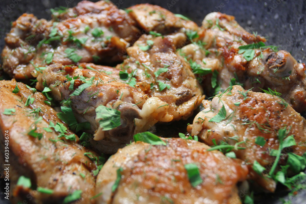 Closeup view of fried chicken with herbs and garlic on frying pan Closeup view of fried chicken with herbs and garlic on frying pan