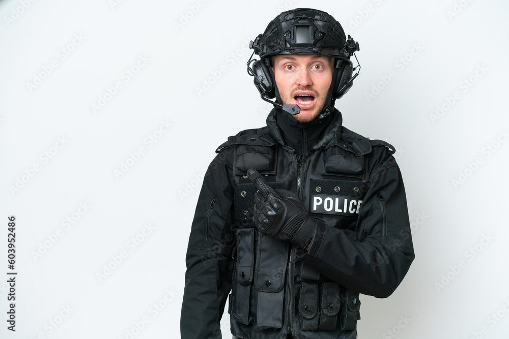 SWAT man over isolated white background surprised and pointing side SWAT man over isolated white background surprised and pointing side