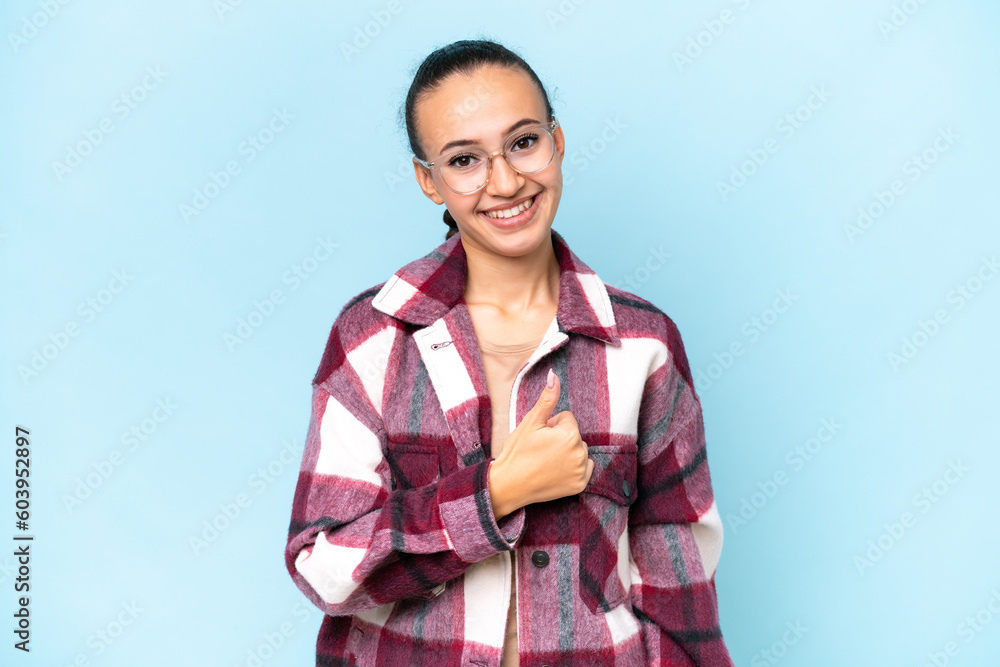 Young Arab woman isolated on blue background giving a thumbs up gesture