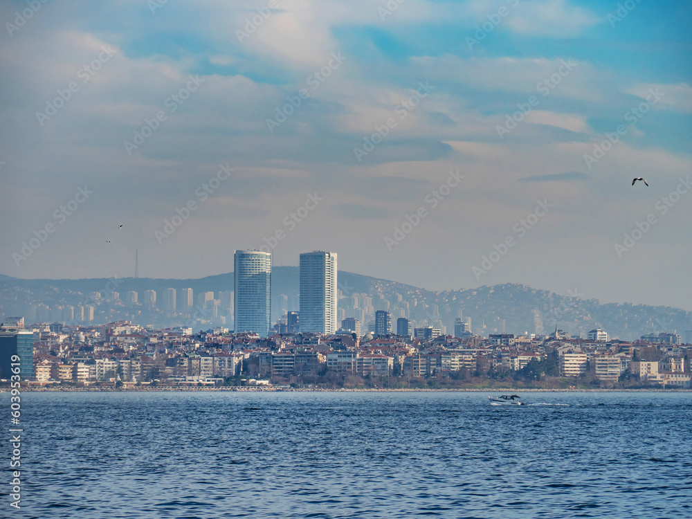 Panorama of the city of Istanbul two large modern skyscrapers opposite each other and small houses. The sea and sky are blue. urban landscape