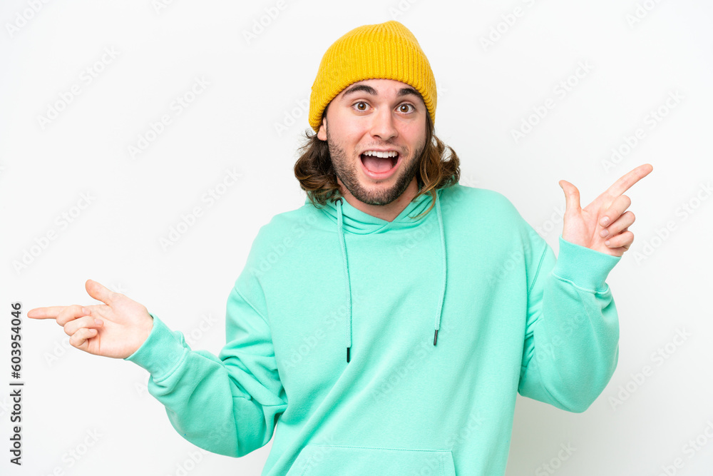 Young handsome man isolated on white chroma background pointing finger to the laterals and happy